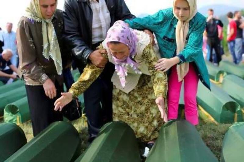 Bosnian women cry near the coffins of their relatives at the Potocari Memorial Centre in Srebrenica, during the burials of 409 newly-identified Bosnian Muslims.