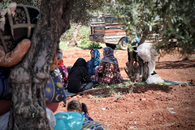 Esraa sitting with a group of women who fled from Latamn.