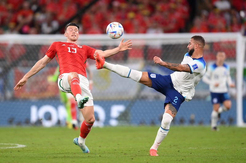 Kieffer Moore of Wales and Kyle Walker of England compete for the ball during the Group B match at Ahmad Bin Ali Stadium. Getty 