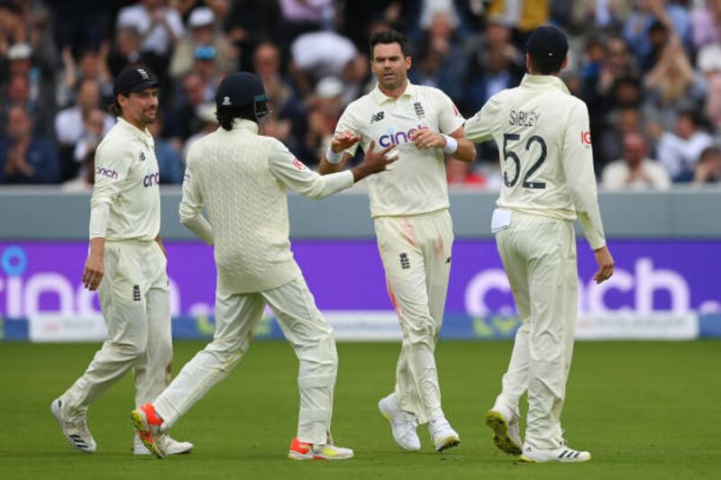 James Anderson celebrates with team mates after dismissing Cheteshwar Pujara.