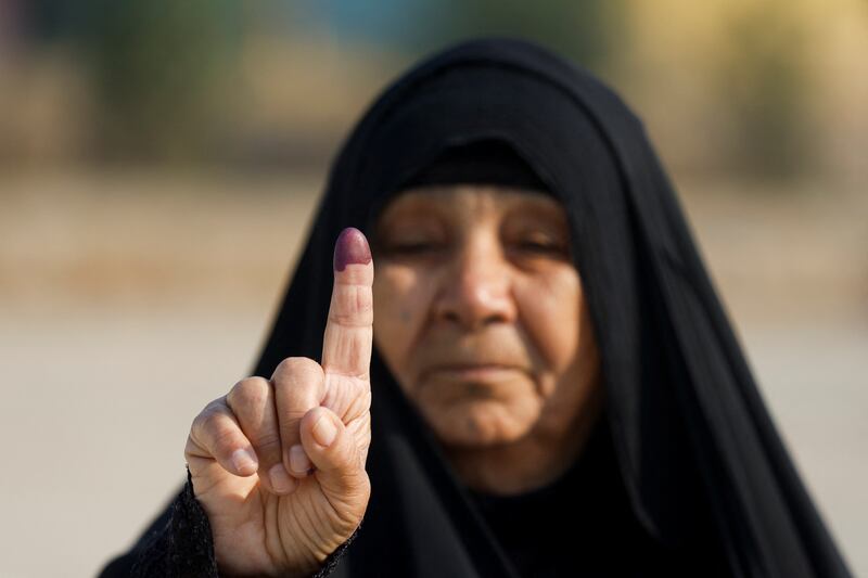 A woman shows her inked finger at a polling station in Mosul after casting her vote during Iraq's provincial council elections. Reuters