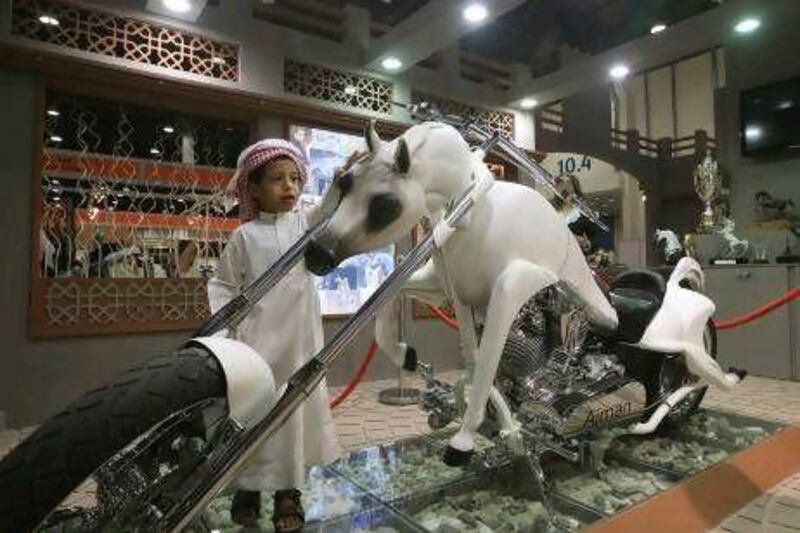 Visitors look at the motorbike designed in the form of a horse on the opening day of the Abu Dhabi International Hunting and Equestrain Exhibition yesterday at Abu Dhabi National Exhibition Centre. Ravindranath K / The National