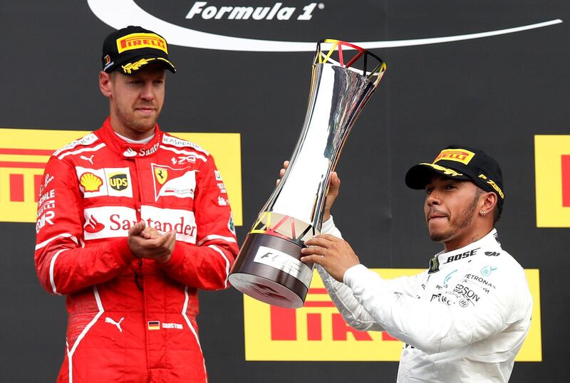 Formula One - F1 - Belgian Grand Prix - Spa-Francorchamps, Belgium - August 27, 2017   Mercedes' Lewis Hamilton celebrates with the trophy after victory in the 2017 Belgian Grand Prix alongside second-placed Ferrari driver Sebastian Vettel  REUTERS/Francois Lenoir     TPX IMAGES OF THE DAY