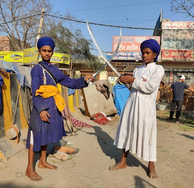 Fatesh Singh, 14, in blue robe and Son Singh, 15, in white robe practicing sword fight at Singhu on a highway connecting capital New Delhi where hundreds of thousands of farmers have set up tent cities for the last 100 days to protest against new controversial farm laws. Taniya Dutta for The National