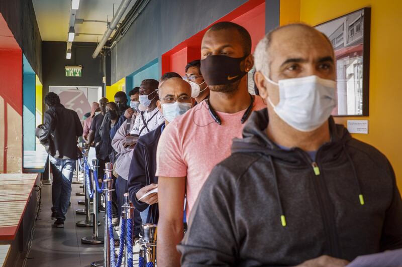 Foreign nationals queue to receive a dose of the Pfizer-BioNTech Covid-19 vaccine at a vaccination centre in Tel Aviv. Bloomberg