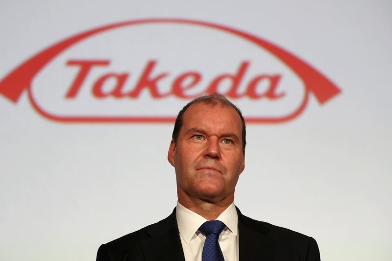 Takeda Pharmaceutical company's president and chief executive officer Christophe Weber stands before a company logo after a press conference in Tokyo on May 9, 2018.
Drug giant Takeda on May 8 said it would buy Irish pharmaceuticals firm Shire in a deal worth 62.5 billion USD, the biggest foreign takeover ever by a Japanese firm. / AFP PHOTO / Behrouz MEHRI