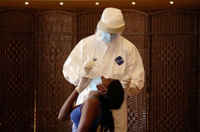 A health worker tests a migrant domestic worker from Africa for the coronavirus disease (COVID-19) at a hotel, before she travels back to her country, in Beirut suburbs, Lebanon. REUTERS