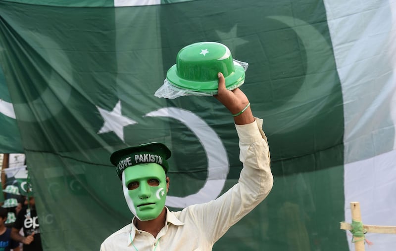 A Pakistani man sells toys around stalls set for the upcoming Independence Day celebrations in Lahore. AFP