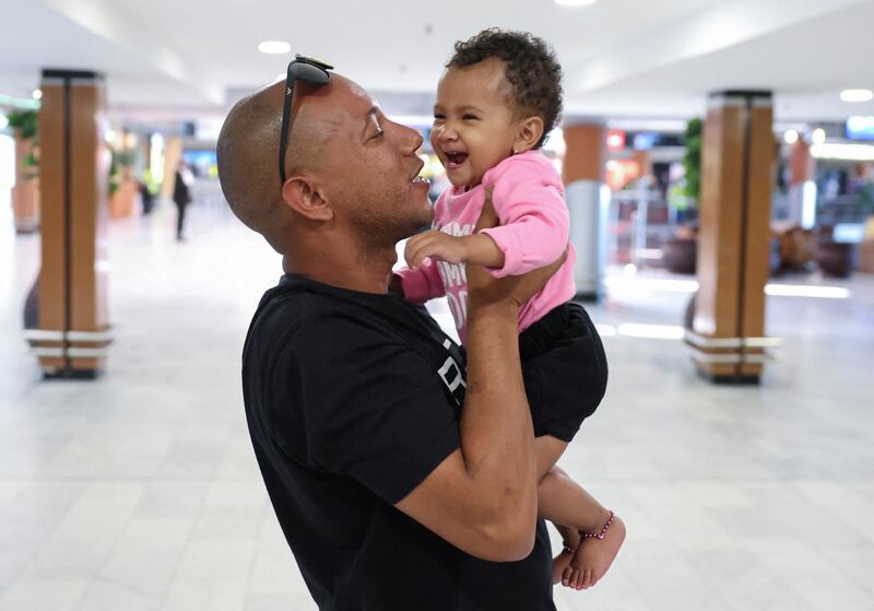 South African evacuee Muzzammil Raubenheimer greets his one-year old daughter Amana after arriving home at Cape Town airport. Reuters