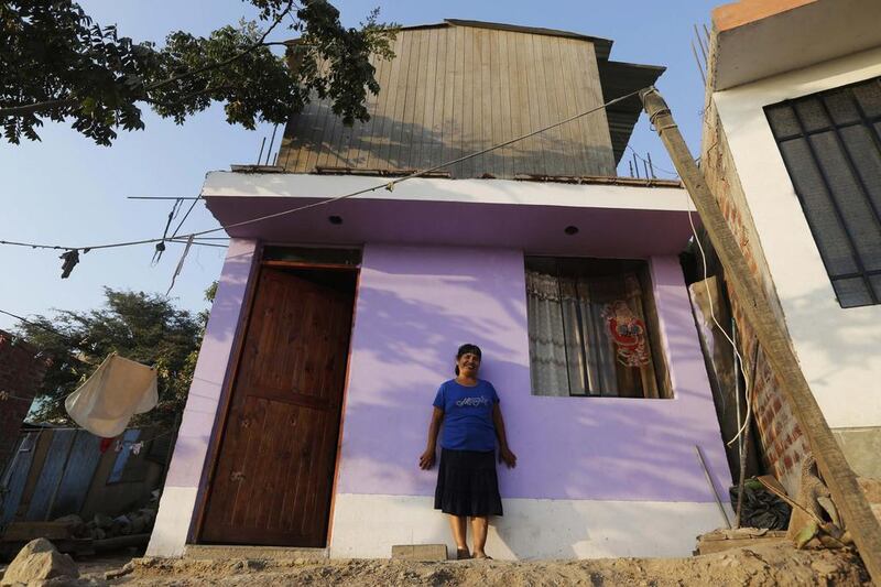 Dorila Gallardo in front of her new home in Gosen City. Gallardo recently managed to build her home after more than 20 years of washing laundry during the day and selling sweets and cigarettes at night. Mariana Bazo / Reuters