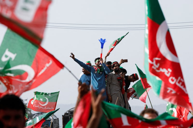 Supporters of Mr Khan wave flags at the rally in Pakistan's capital. Reuters
