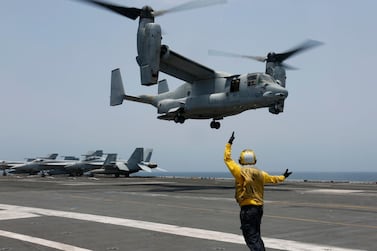 Aviation Boatswain's Mate 2nd Class Nicholas Hawkins signals an MV-22 Osprey to land on the flight deck of the Nimitz-class aircraft carrier USS Abraham Lincoln in the Arabian Sea. US Navy via AP