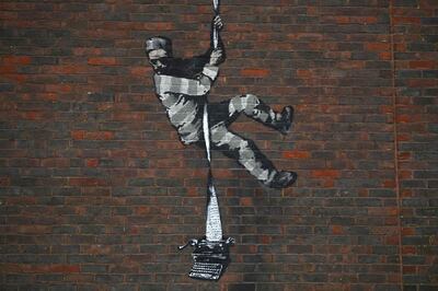 (FILES) This file photo taken on March 02, 2021 shows an artwork by street artist Banksy on the side of Reading Prison in Reading, west of London.  Street artist Banksy on March 4 claimed responsibility for a painting on the wall of a former British prison that once held playwright Oscar Wilde. The artwork shows a prisoner escaping on a rope made of bedsheets tied to a typewriter.
 - RESTRICTED TO EDITORIAL USE - MANDATORY MENTION OF THE ARTIST UPON PUBLICATION - TO ILLUSTRATE THE EVENT AS SPECIFIED IN THE CAPTION
 / AFP / BEN STANSALL / RESTRICTED TO EDITORIAL USE - MANDATORY MENTION OF THE ARTIST UPON PUBLICATION - TO ILLUSTRATE THE EVENT AS SPECIFIED IN THE CAPTION

