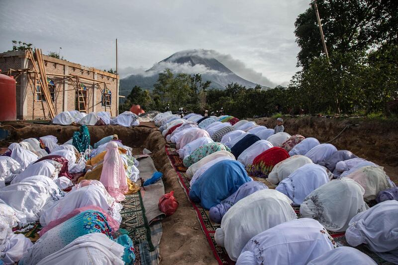 Muslims take part in a prayer celebrating the Eid al Fitr festival near Mount Sinabung in Karo, North Sumatra, Indonesi. Ivan Damanik / AFP