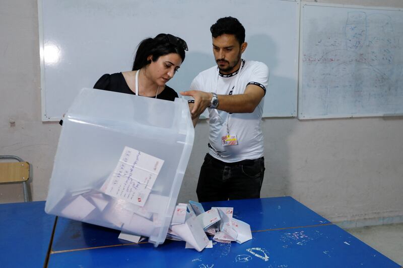 Members of the election committee open the ballot box at a polling station in Tunis. Reuters