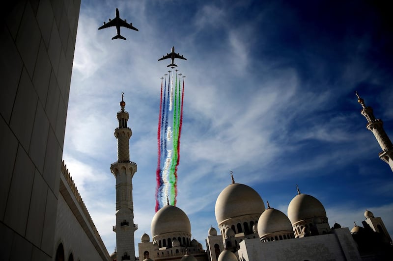 Two Etihad and Emirates planes, followed by the Al Fursan aerobatic team, perform a display show over the Sheikh Zayed Grand Mosque to celebrate the UAE's 47th National Day and the Year of Zayed, in Abu Dhabi, United Arab Emirates, Sunday, Dec. 2, 2018. (AP Photo/Kamran Jebreili)