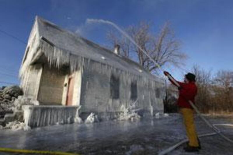 Gregory Holm sprays water on an abandoned house in Detroit. He and another artist hope their installation draws attention to the housing crisis. Art projects such as this are playing a part in raising the battered city's profile and refurbishing its blighted areas.