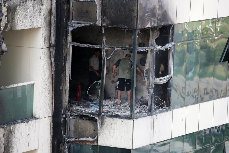 A resident looks for his belongings in Tamweel tower in Dubai's Jumeirah Lake Towers after fire gutted the building in 2012.  Pawan Singh / The National