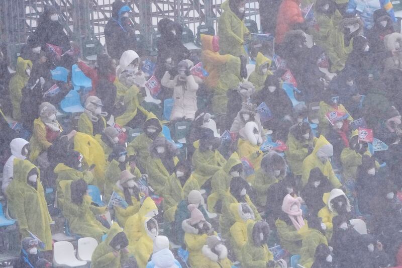 Spectators watch during the mixed team snowboard cross finals as the snow falls at the 2022 Beijing Winter Olympics. AP Photo