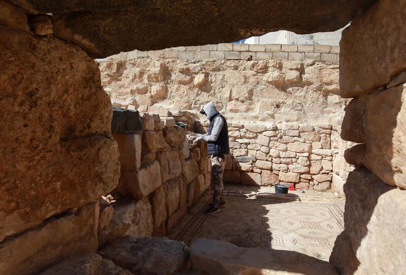 A worker restores a stone wall at the ancient church complex in Rihab, Jordan. Workers earn between 12.5 Jordanian dinars ($18) and 15 Jordanian dinars a day. AFP