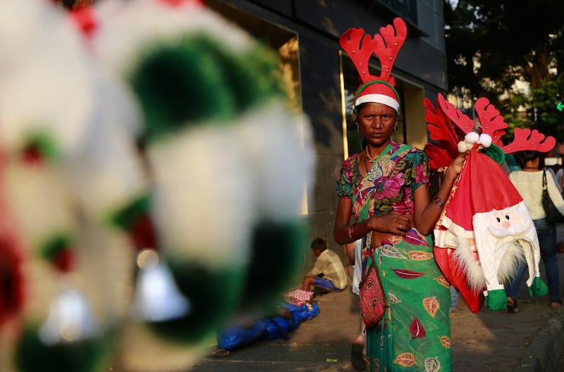 A roadside vendor holds Christmas ornaments and hats for sale in Mumbai, India.  Rafiq Maqbool / AP Photos