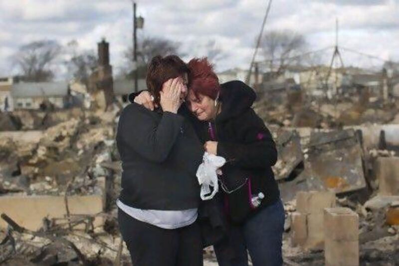 Neighborus Lucille Dwyer (right) and Linda Strong embrace after looking through the wreckage of their homes devastated by fire in the wake of Hurricane Sandy at New York’s Breezy Point.