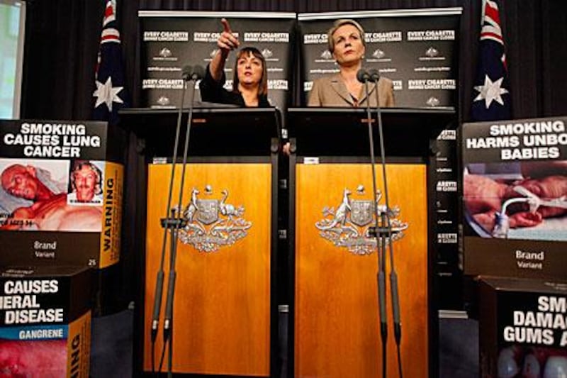 Australian Attorney General Nicola Roxon left, and the Tanya Plibersek, the health minister, speak after Australia’s highest court ruled it was legal for the government to make tobacco companies package cigarettes without prominent branding.