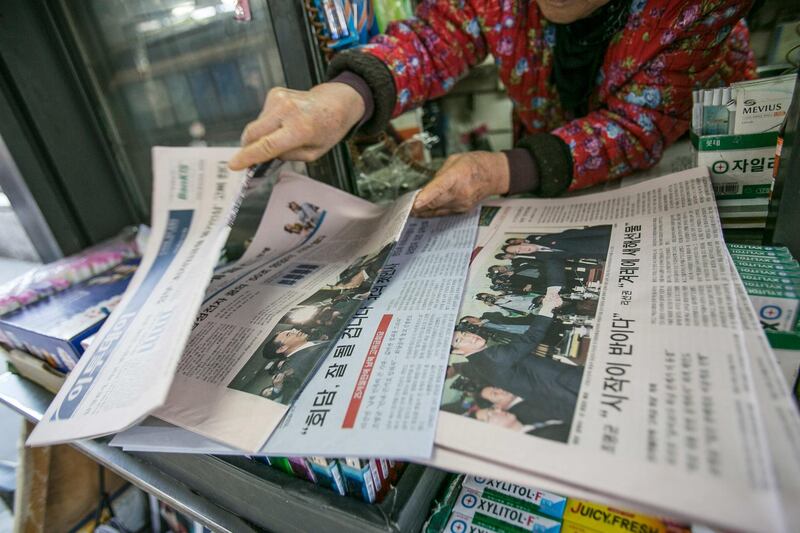 A vendor sorts through newspapers featuring photographs of Cho Myoung-gyon, South Korea's unification minister, left, shaking hands with Ri Son Gwon, chairman of North Korea’s Committee for the Peaceful Reunification of the Fatherland, on the front page at a kiosk in Seoul, South Korea, on Tuesday, Jan. 9, 2018. North Korea said it would send a high-level delegation to the Winter Olympics in South Korea next month while expressing a desire to resolve issues on the divided peninsula through dialogue and negotiations. Photographer: Jean Chung/Bloomberg