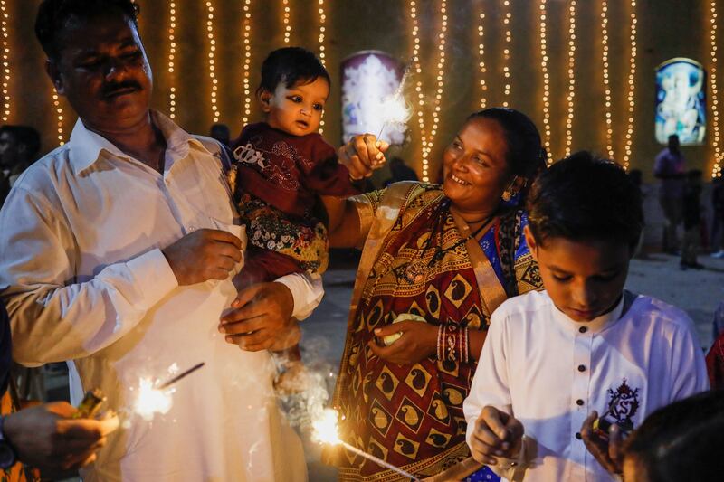 Sawantri, 40, helps her son to wave a burning sparkler during Diwali celebrations in Karachi, Pakistan. Reuters