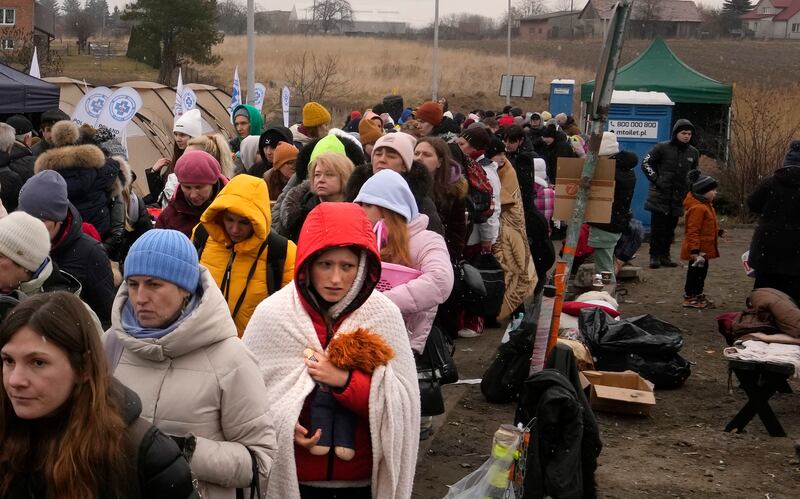 A young woman clutches a doll as she crosses the border in Medyka, Poland. AP Photo / Markus Schreiber