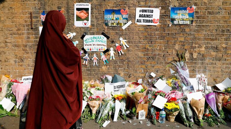 (FILES) This file photo taken on June 20, 2017 shows people stopping to read tributes and look at plawers placed in the Finsbury Park area of north London on June 20, 2017, for the victims of a alleged van attack on pedestrians nearby on June 19. 
A British man "obsessed" with Muslims deliberately drove into a group outside a mosque in an act of terrorism intended to kill as many as possible, a court heard on January 22, 2018. Darren Osborne is accused of murdering 51-year-old Makram Ali and trying to murder others in the Finsbury Park area of north London on June 19 last year, after growing angry at recent terror attacks and child sexual exploitation scandals involving gangs of mainly Muslim men. Osborne, 48, from the Welsh capital Cardiff, denies the charges.
 / AFP PHOTO / Tolga AKMEN
