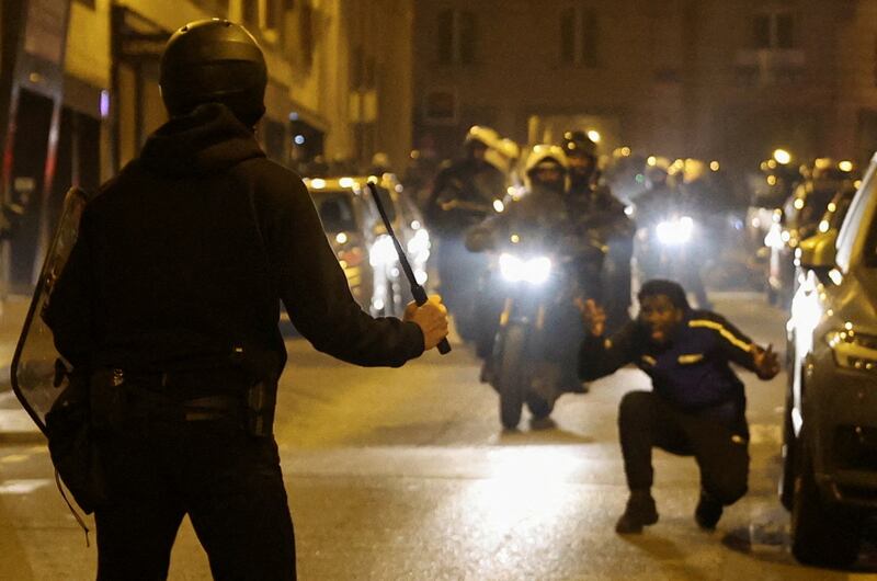 Riot officer with baton approaches protester in Paris. Reuters
