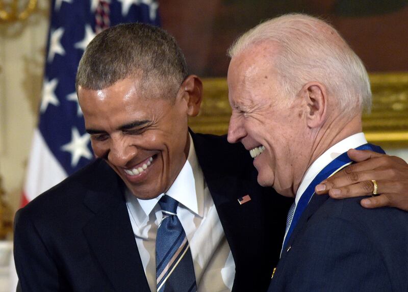 Former US president Barack Obama laughs with Mr Biden, who was vice president at the time, during the ceremony in which Mr Obama presented Mr Biden with the Presidential Medal of Freedom on January 12, 2017. AP