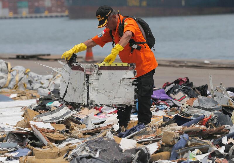 A rescuer inspects parts of the crashed plane. AP Photo