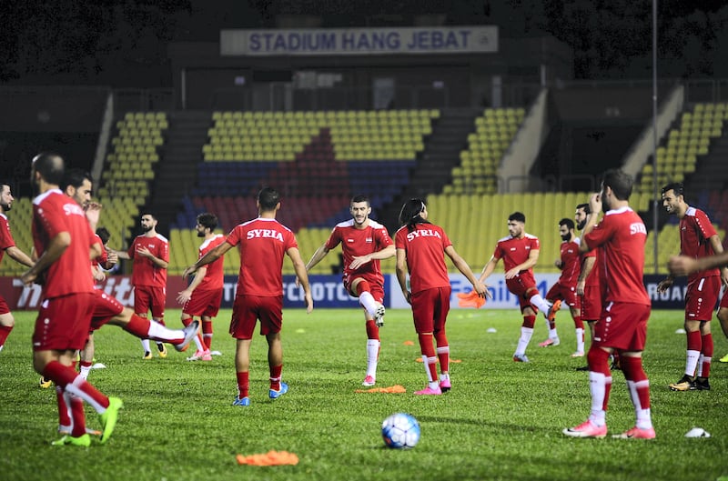 Members of Syria's national football team warm up during an official training session a day ahead of the 2018 World Cup qualifying football match between Syria and Australia at the Hang Jebat Stadium in Malacca, on October 4, 2017. / AFP PHOTO / NAZRULHAD HASHIM