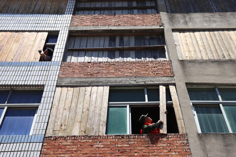 A paramilitary police officer boards up a window in preparation for the approaching super Typhoon Maria in Wenzhou, Zhejiang province, China. Reuters