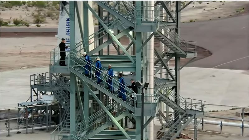 This still image taken from video by Blue Origin shows Funk, Jeff and Mark Bezos, and Daemen as they ascend the crew tower for the flight.