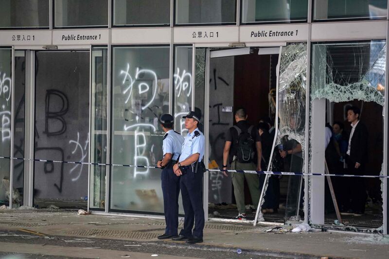 Police stand outside the government headquarters in Hong Kong on July 2, 2019, a day after protesters broke into the building. Hong Kong's leader on July 2 condemned "the extreme use of violence" by masked protesters who stormed and ransacked the city's legislature in an unprecedented challenge to Beijing's authority. / AFP / Vivek PRAKASH
