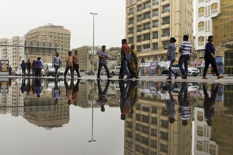 Pedestrians negotiate the flooded Khalid bin Al Waleed road in Dubai. Christopher Pike / The National