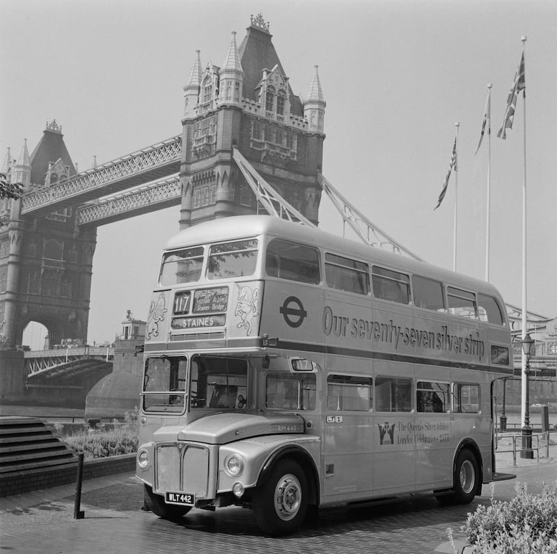 A double-decker bus in livery commemorating the silver jubilee  on the Thames Embankment in London.