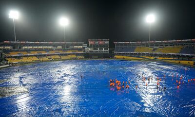 Ground staff stand on the covered field after rain interrupted the Asia Cup match between India and Pakistan. AP