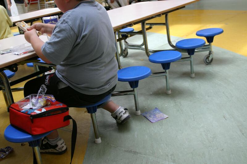 ABWB6E An overweight boy eats snacks for lunch at school, London, UK.. Image shot 2004. Exact date unknown.