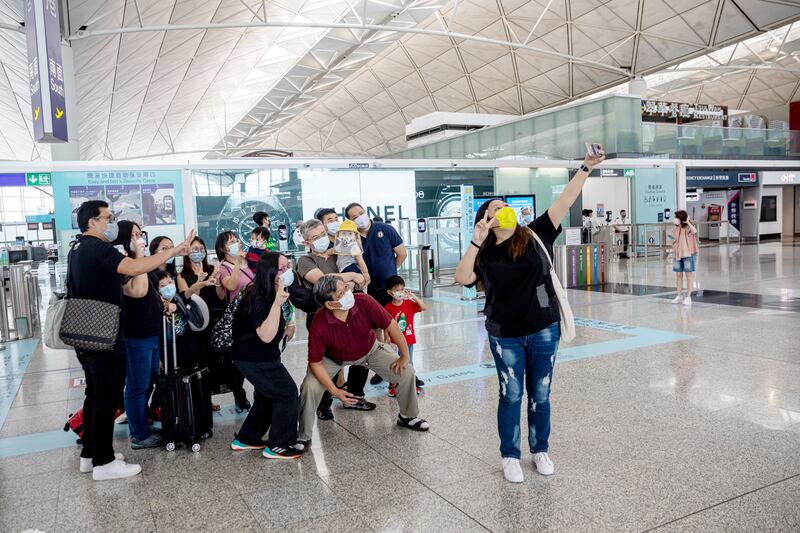 Hong Kongers departing for London take selfies with relatives and friends at the Hong Kong International Airport in August 2021. EPA