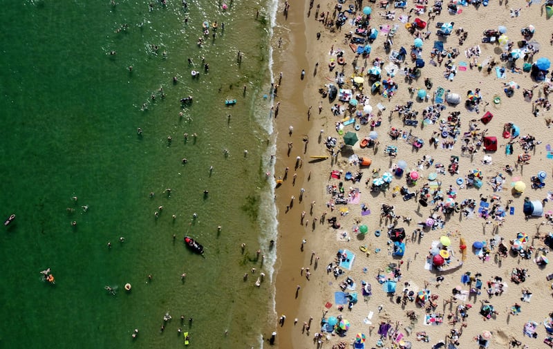 People relax at Bournemouth Beach, Britain, as a heatwave sends temperatures soaring across the country. Reuters