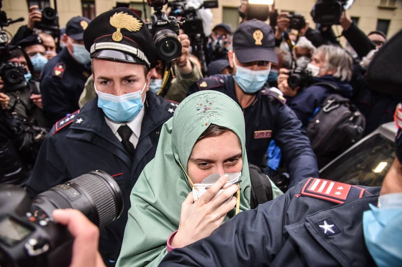 Silvia Romano reacts as she arrives at her home wearing a protective mask, Milan, Italy.  EPA