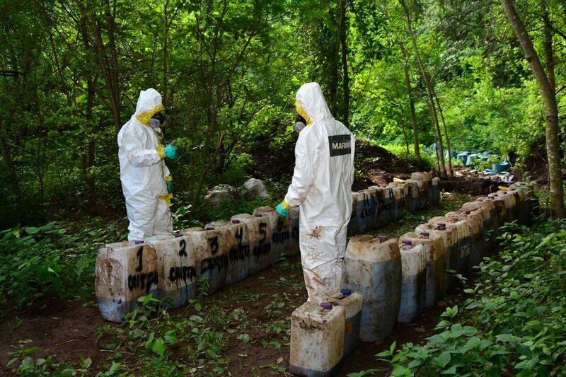 Forensic technicians of the Mexican Navy are seen at a clandestine drug processing laboratory where they seized 50 tons of methamphetamine discovered during an operation in the town of Alcoyonqui. Reuters