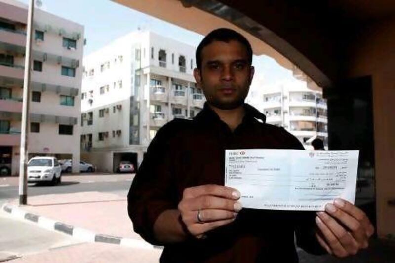 Amanullah Jamal holds the cheque from the Government of Sharjah that will help him and his family rebuild after fire gutted their apartment in Al Baker 4 Tower last month.