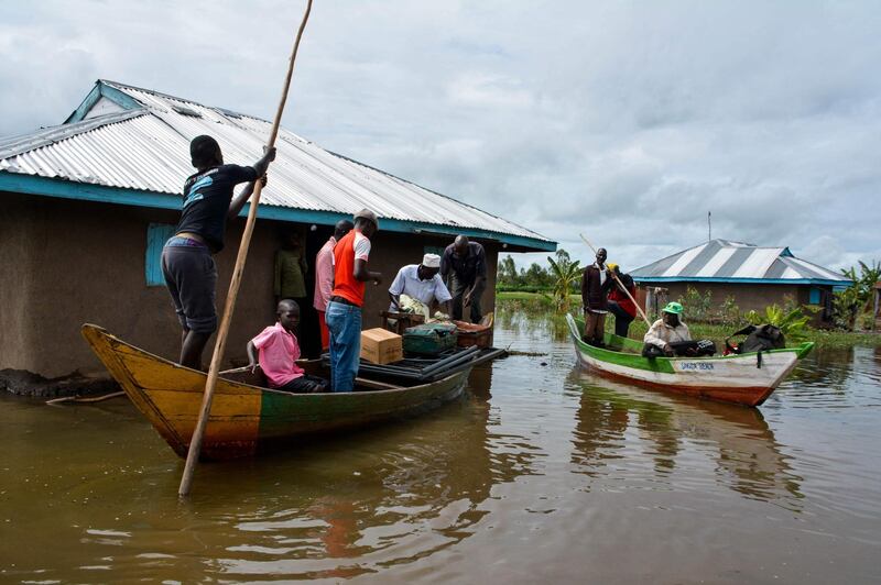 Rescue boats evacuate families after their houses were flooded in K'akola village in Nyando sub-county in Kisumu on December 3, 2019. At least 210 families in Nyando have been displaced by floods in the area. / AFP / CASMIR ODUOR
