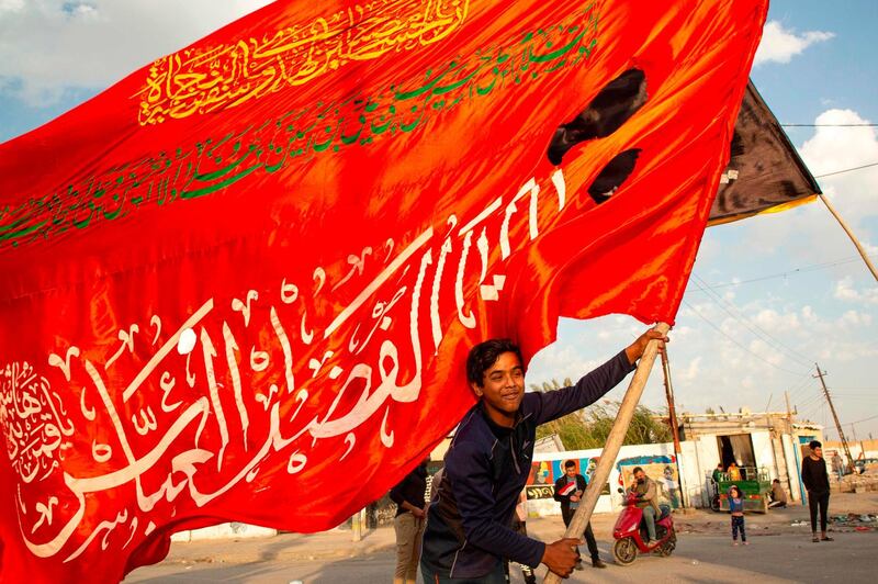 An Iraqi demonstrator waves a religious flag during an anti-government demonstration in the southern city of Basra. AFP