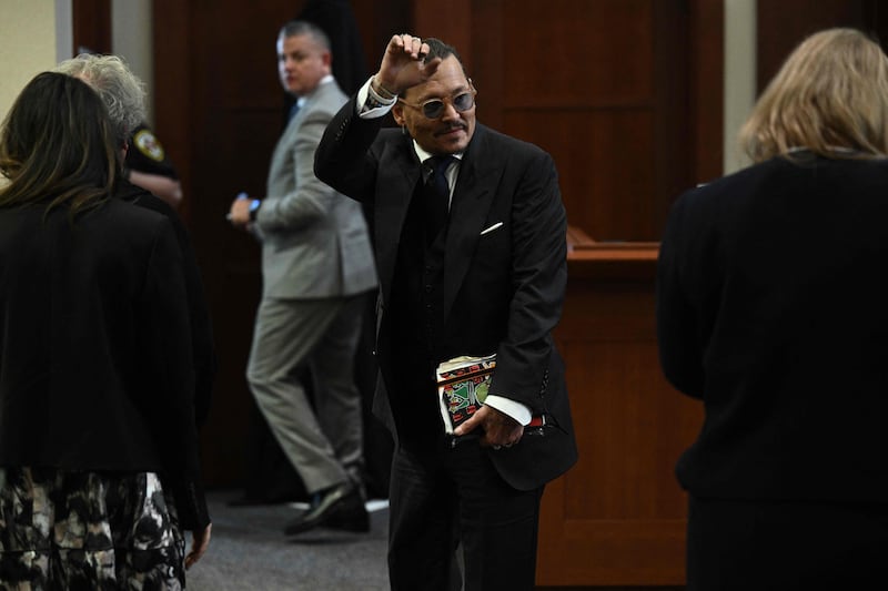 Depp gestures to his fans in the courtroom. AFP